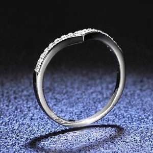 Macro detail of V-shaped silver ring with pavé cubic zirconia on dark background