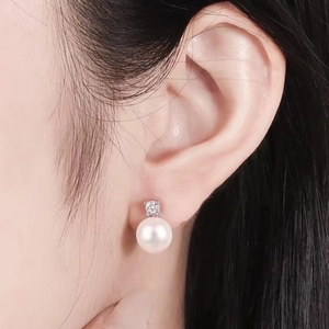 Elegant freshwater pearl stud earrings with zircon inlay on silver base worn by model