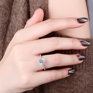 Detailed view of 1 carat moissanite halo ring with pave band on a model hand