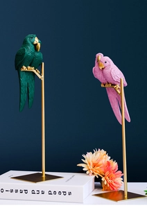 Close-up of resin parrot statues with fine feather texture and golden metal base