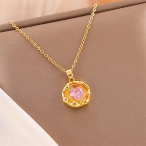 Vintage gold titanium steel necklace with a pink heart zircon pendant on a soft background