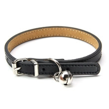 Detalle de collar de cuero negro para mascotas con hebilla plateada y cascabel