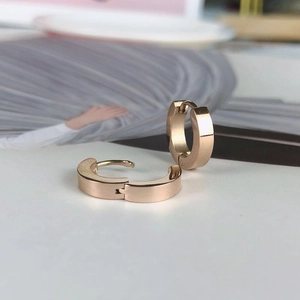 Close-up of polished rose gold hoop earrings with white zircon on a clean white background