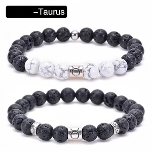 Macro detail of Taurus constellation beads on black lava stone and white turquoise bracelets