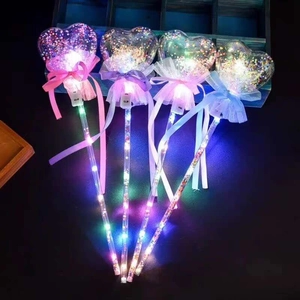 Close-up of four glowing heart-shaped fairy wands with LED lights and colorful ribbons