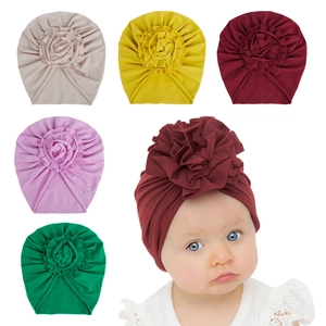 Détail de turbans en coton pour bébé avec fleurs plissées déclinés en cinq couleurs