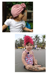 Détail du bonnet turban pour bébé en coton rose avec grande fleur en tissu décorative