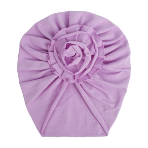 Détail du turban violet pour bébé en maille douce avec une grande fleur faite à la main