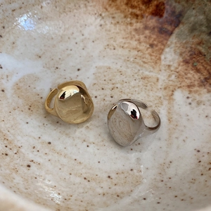 Macro detail of irregular gold and silver 925 sterling silver rings in a ceramic bowl