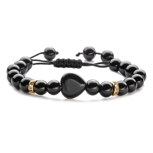 Detail of adjustable black beaded bracelet featuring a heart charm and gold pavé spacers