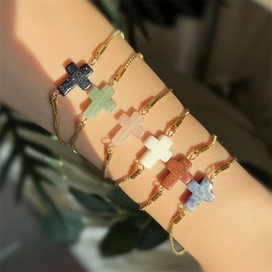 Close-up of six colorful natural stone cross pendants on gold adjustable chains