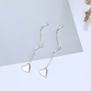 Detail of silver wavy ear threads with heart charms and elegant tassel chain design