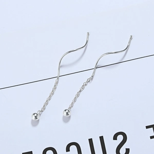 Macro detail of S925 sterling silver wave threader earrings with sleek metal chain and ball