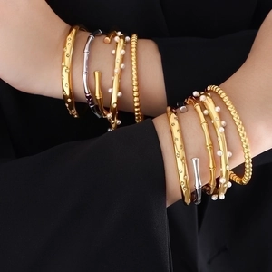 Bohemian gold and silver titanium steel bracelet set with pearls on a model wrist