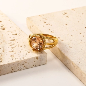 Detail of 18K gold plated steel ring with champagne zircon on natural stone