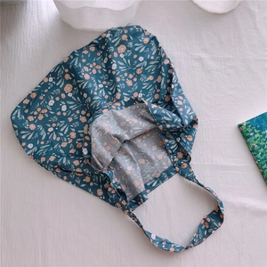 Close-up of floral print tote bag with teal fabric and soft cotton texture