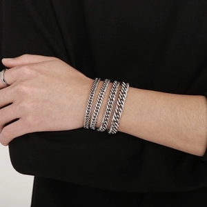 Detailed close-up of a silver stainless steel Cuban link bracelet wrapped on a wrist