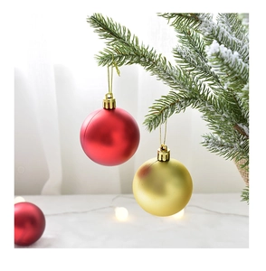 Primer plano de bolas de Navidad mate rojas y doradas en ramas de pino nevadas