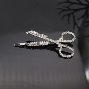 Macro shot of silver scissor shaped hair clip with dense sparkling rhinestones detail