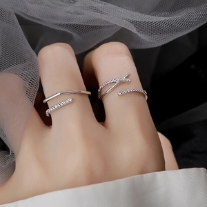Primo piano di anelli aperti placcati in argento dal design semplice e pietre sul dito