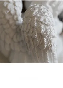 Détails des textures de plumes sur les ailes de la statue d'ange en résine blanche