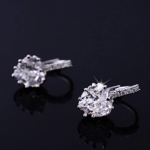 Macro shot of heart-shaped cubic zirconia earrings with pavé set accents on silver hoop