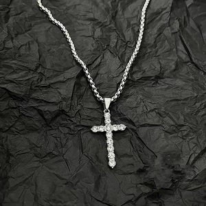 Hip hop silver cross necklace with pavé zircons on black background with twist rope chain