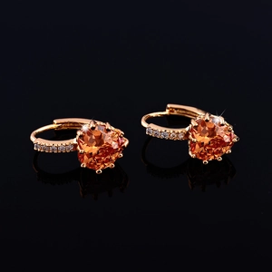Detailed macro of golden heart-shaped zircon earrings with white pave crystals