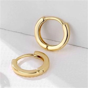 Close-up of small golden hoop earrings showing front and side views in polished metal
