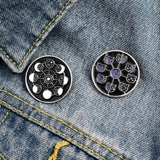 Detailed shot of moon phase and cat enamel pins on denim jacket lapel accessory