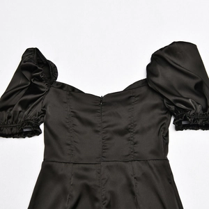 Detail view of black satin dress back with invisible zipper and elegant puff sleeves