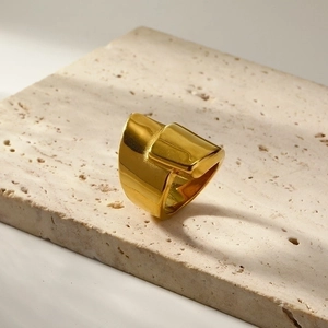 Irregular wide band 18k gold plated stainless steel ring on beige stone background