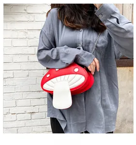 Outdoor lifestyle shot of a creative red mushroom PU leather crossbody bag with chain