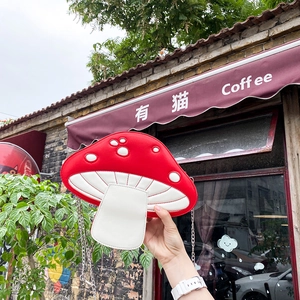 Detail of red and white mushroom shaped PU crossbody bag with silver chain strap