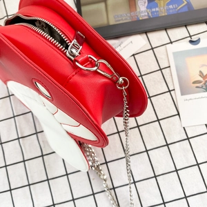 Detail view of red and white mushroom-shaped PU leather crossbody bag with silver chain