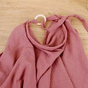 Detail of dusty pink muslin nursing cover with breathable texture and white plastic ring