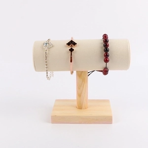 Close-up of T-bar jewelry stand with natural wood base and beige velvet bracelet holder