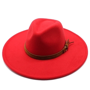 Detailed texture of red wool felt hat with brown leather band and metallic buckle