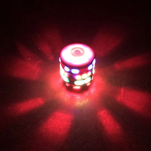 Detail of LED music gyro toy spinning with bright red and blue lights in the dark