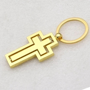 Macro shot of a golden double-layered rotating cross pendant for car keychains