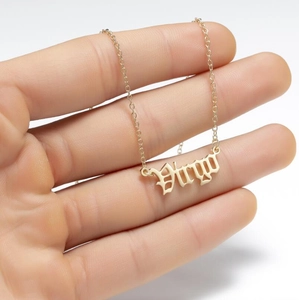 Detail view of gold stainless steel Virgo zodiac pendant necklace on a delicate cross chain