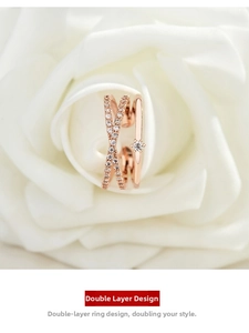 Close-up of double-layer rose gold cross ring with pavé diamonds on white rose petals