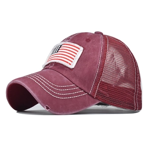 Detail of burgundy ponytail baseball cap with distressed brim and American flag embroidery