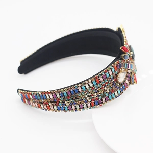 Detailed close-up of Baroque wide headband featuring colorful rhinestones on black fabric