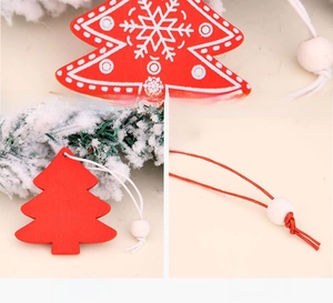 Detail of red wooden Christmas tree pendant with snowflake pattern and white hanging bead