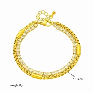 Golden double-layer chain bracelet with zircon accents and cylindrical charms on white background