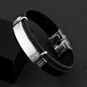 Close-up of black braided leather bracelet with a polished stainless steel metal plate