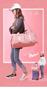 Pink waterproof travel bag showing the trolley sleeve functionality for luggage attachment