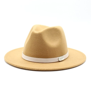 Detail of camel fedora hat featuring white leather band and silver metal buckle