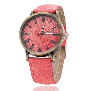 Dettaglio dell'orologio in denim rosso con cassa in bronzo e numeri romani classici
